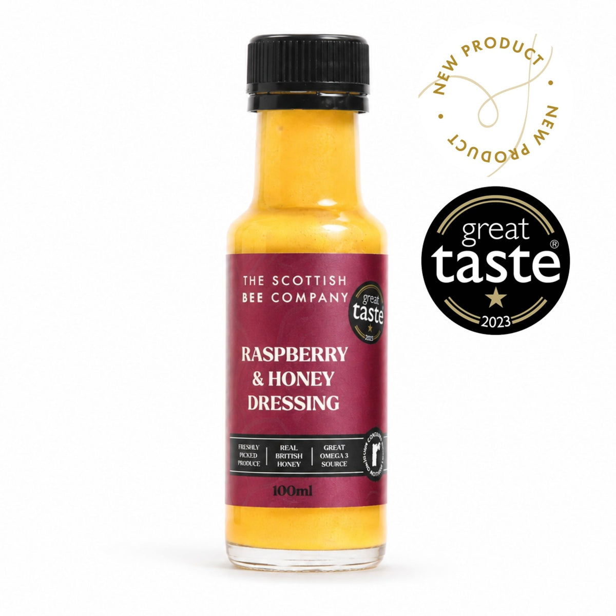 A 100ml bottle of The Scottish Bee Company Raspberry & Honey Dressing, showing the yellow-orange liquid inside, a dark red label, and a black cap. Two badges are displayed on the right: a gold &
