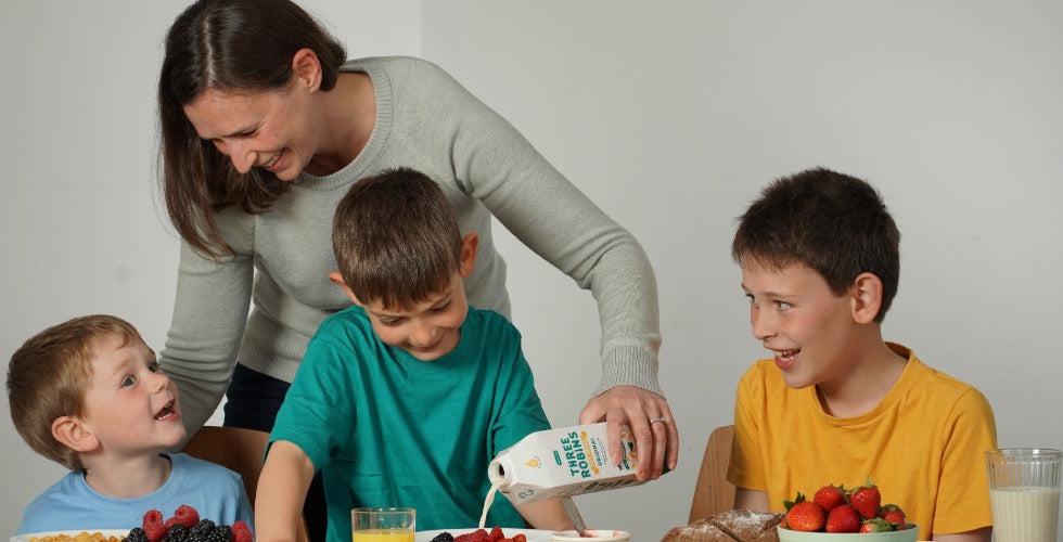 Founder of Three Robins with her 3 kids, pouring her oat milk