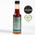 A bottle of Kimchi Hot Honey Drizzle with the label showing the product name and the award seals from Great Taste and Farm Shop & Deli 24 Gold.